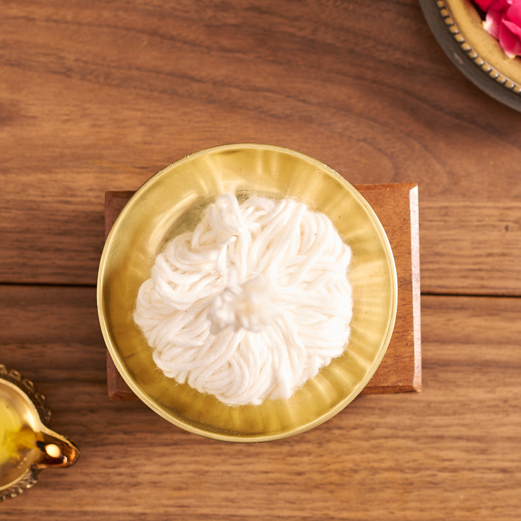 White flower in a gold bowl on a wooden surface