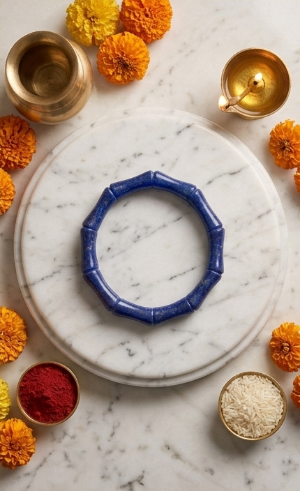 Triptych of a blue bracelet on a marble surface with decorative elements and candles.