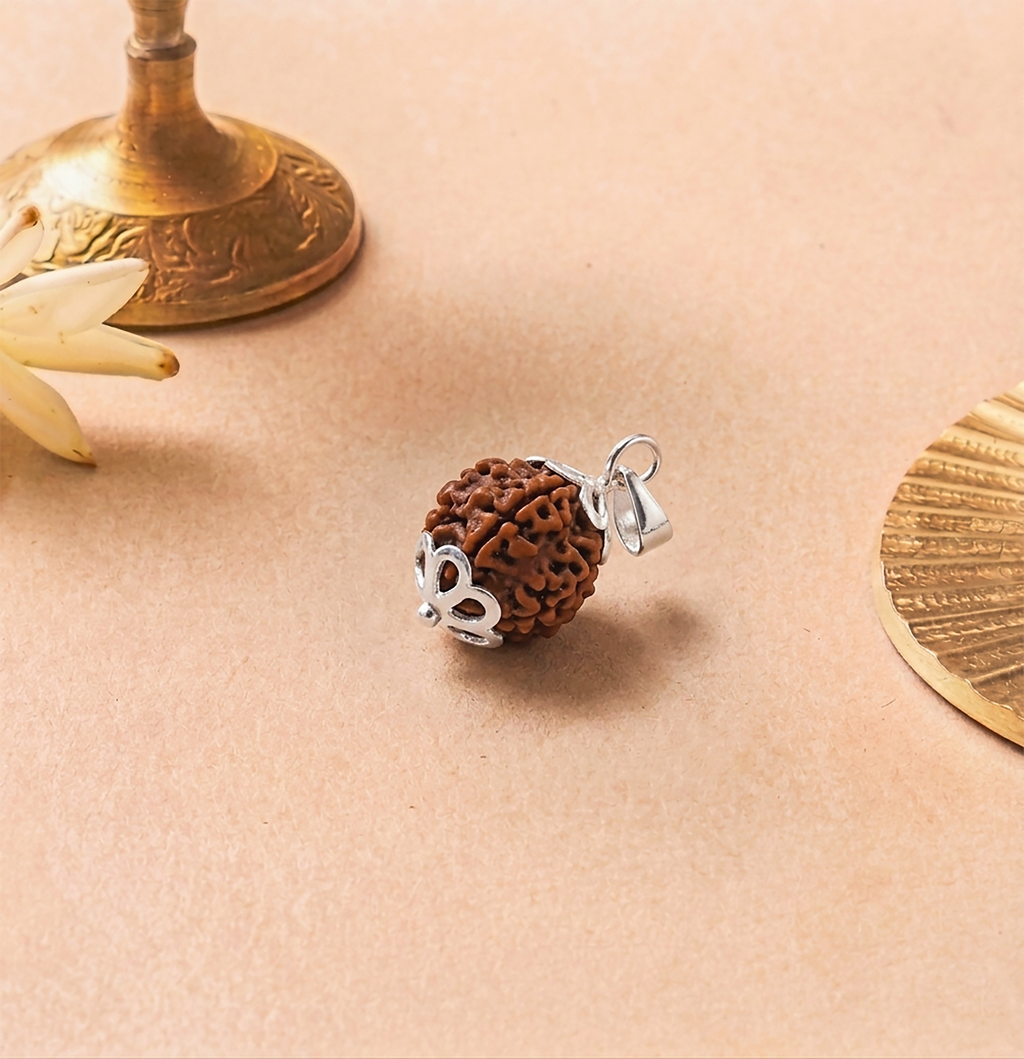 Brown textured pendant with silver heart charm on a beige surface