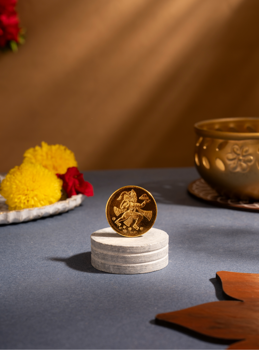 Gold coin with intricate design on a white pedestal against a warm-toned background with decorative elements.