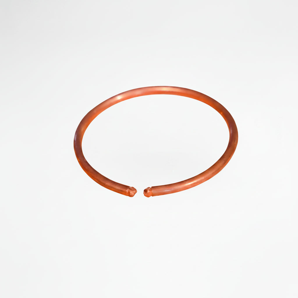 Orange rubber band with measurements on a white background