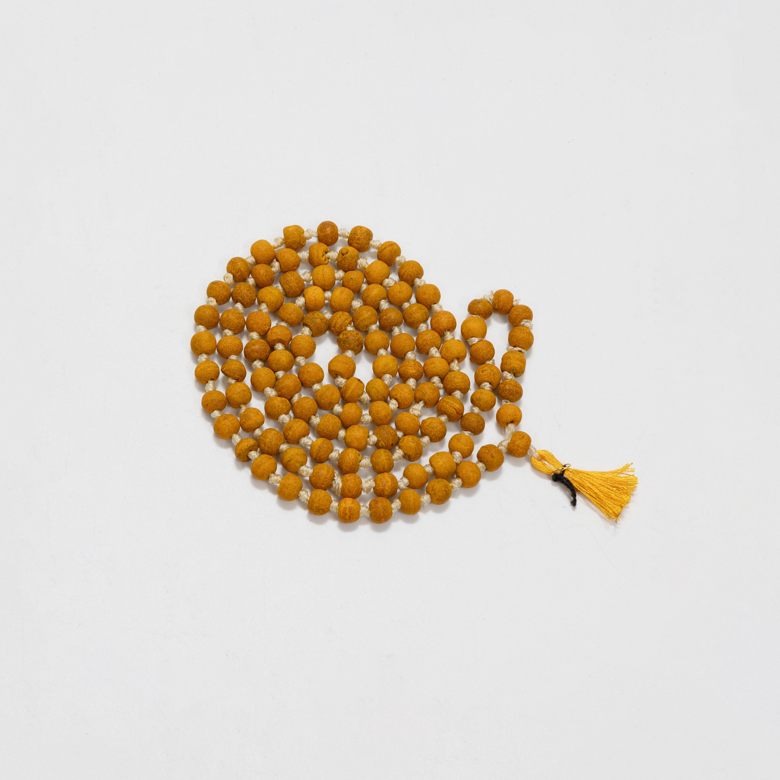 String of yellow beads with a tassel on a white background