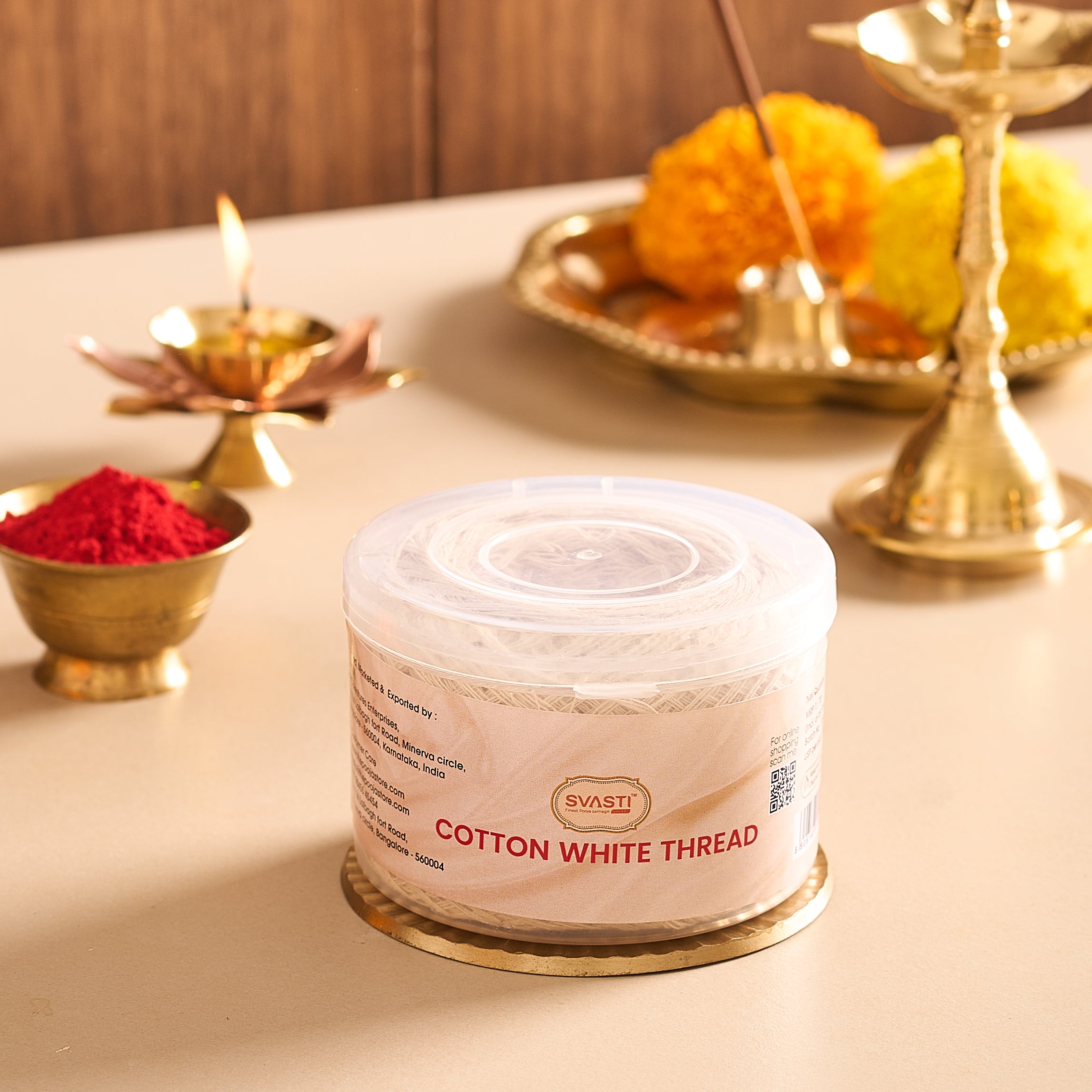 Spool of cotton white thread with Diwali decorations in the background