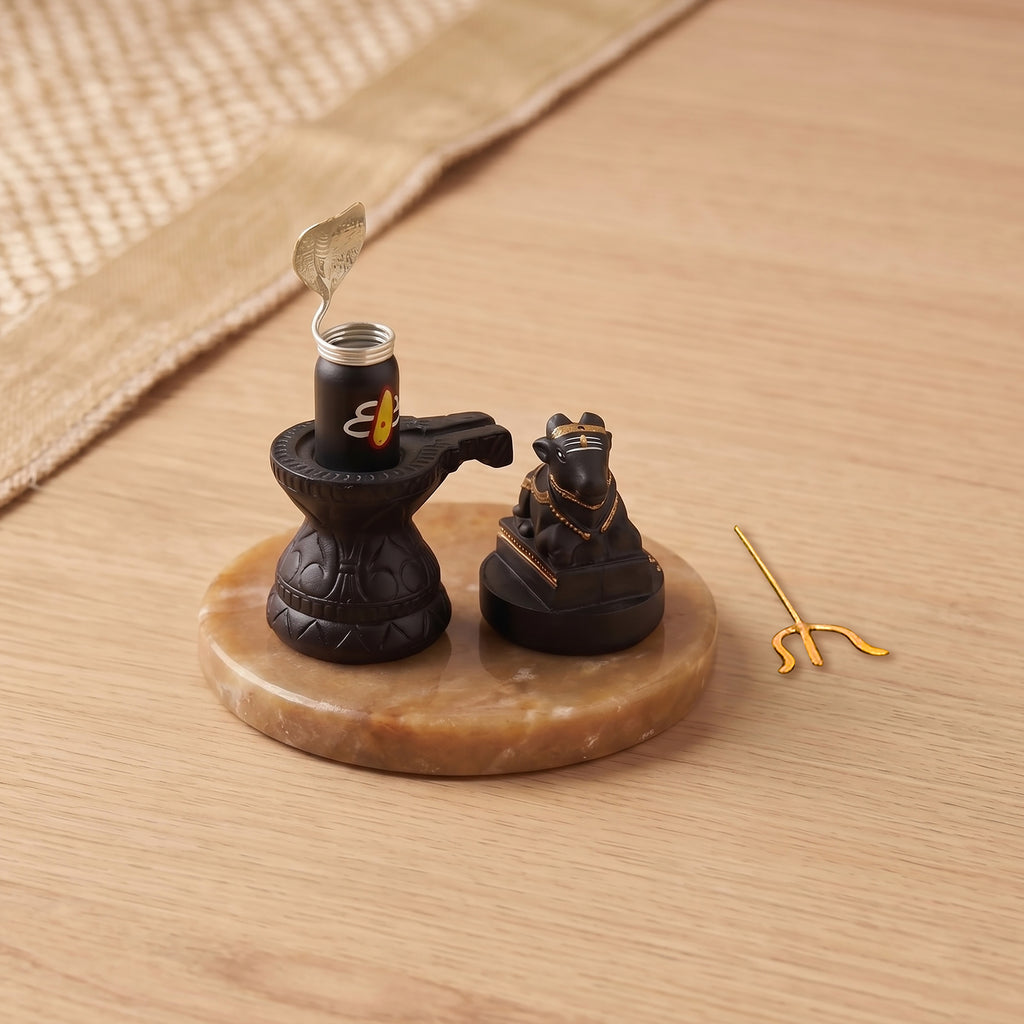Decorative item with a candle and two figurines on a wooden surface