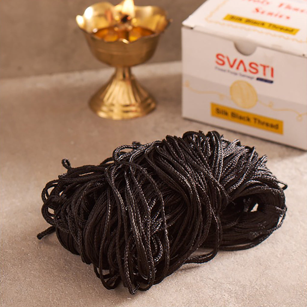 Ball of black thread with SVASTI packaging in the background