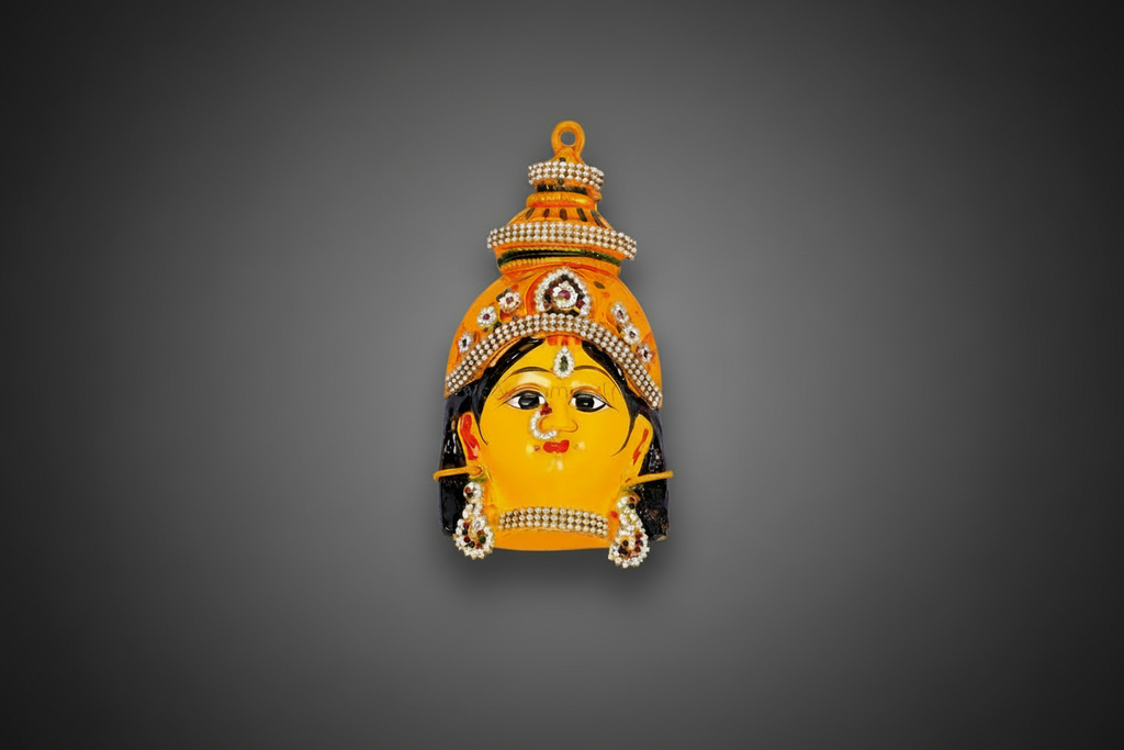 A decorative wall pin or brooch shaped like a stylized face with a crown, shown against a dark textured background.