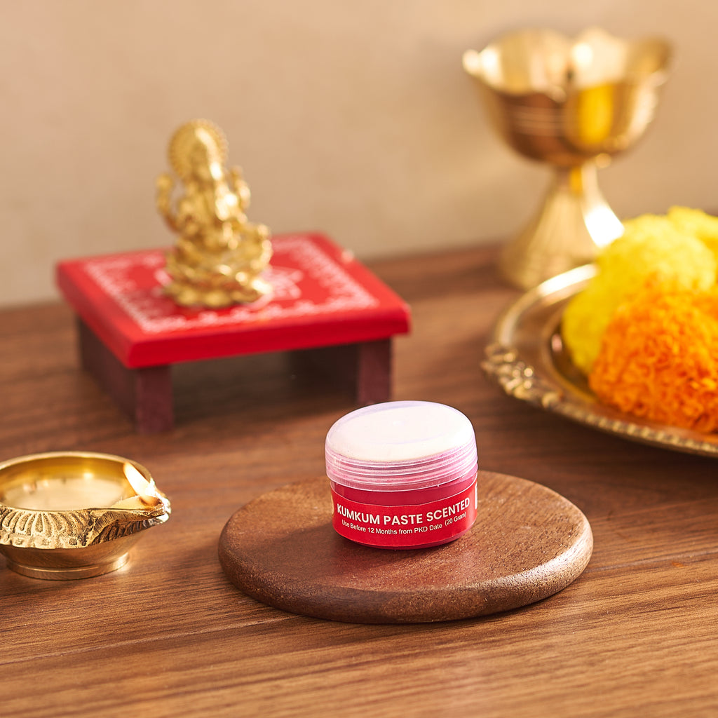 Small container of scented balm on a wooden surface with decorative items in the background