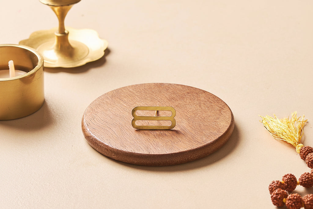 Wooden coaster with gold coaster holder on a beige surface