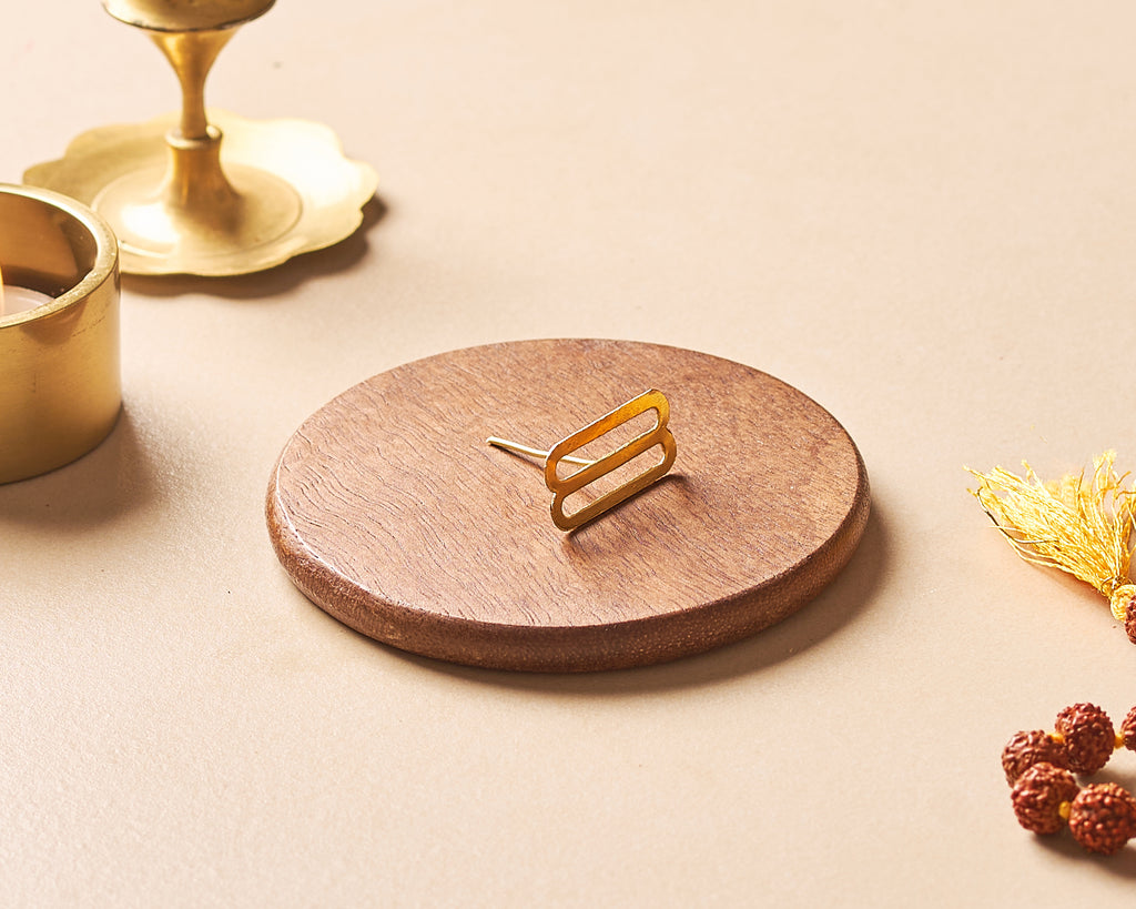 Wooden coaster with gold coaster holder on a beige surface