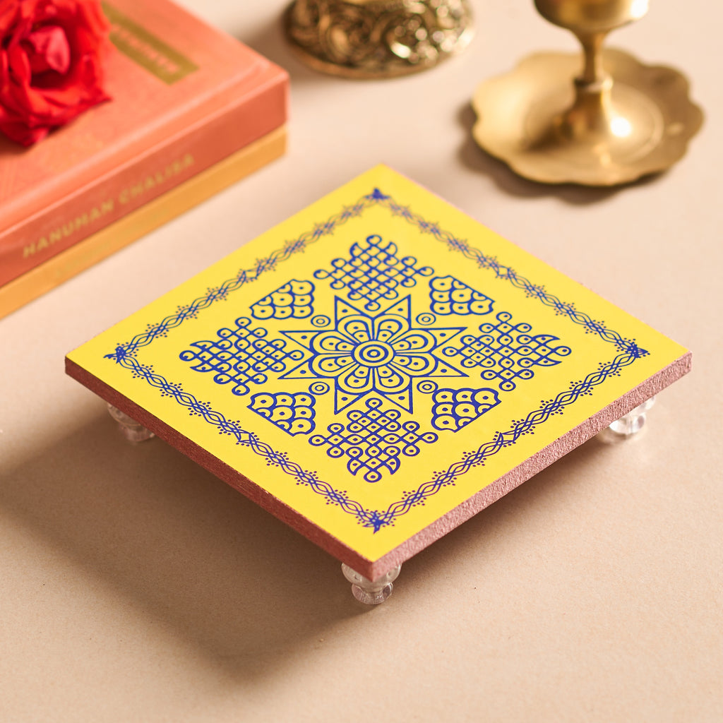 Decorative yellow and blue coaster with intricate design on a beige surface