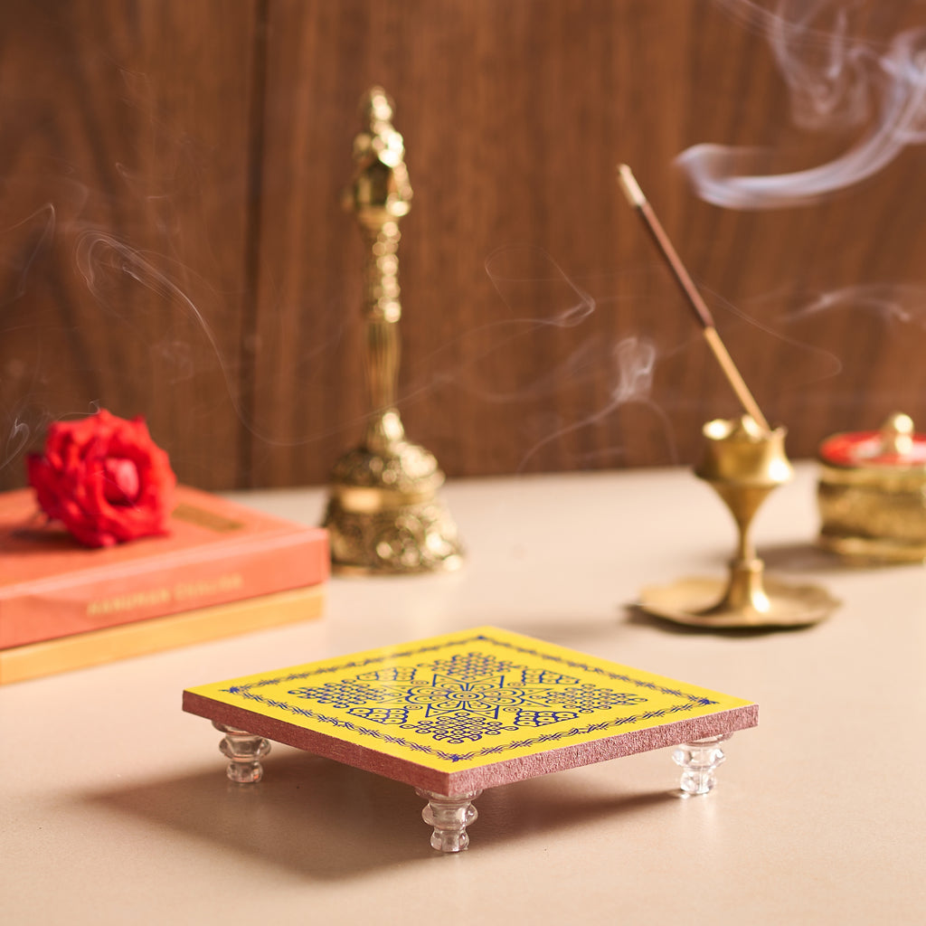 Incense burner with incense sticks and smoke on a wooden surface