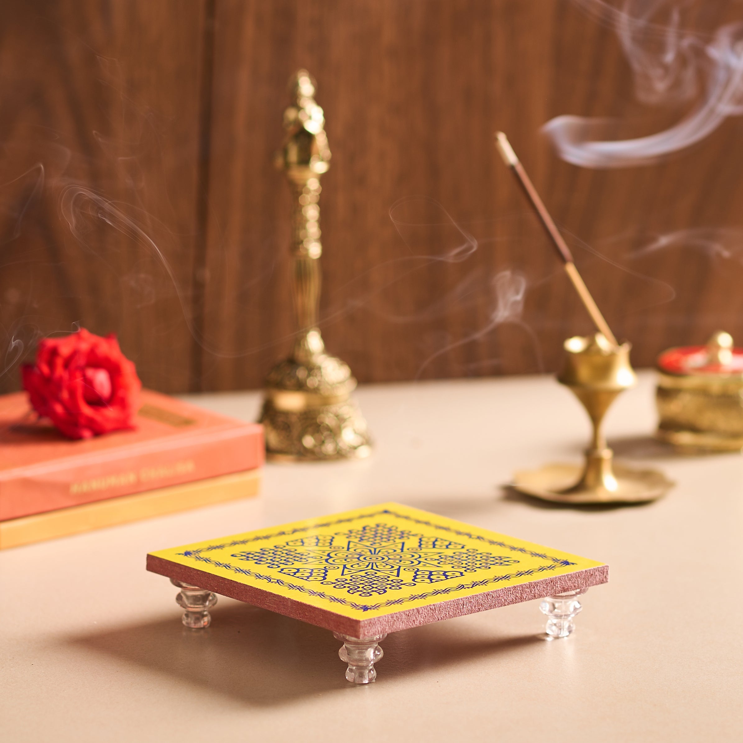 Incense burner with incense sticks and smoke on a wooden surface