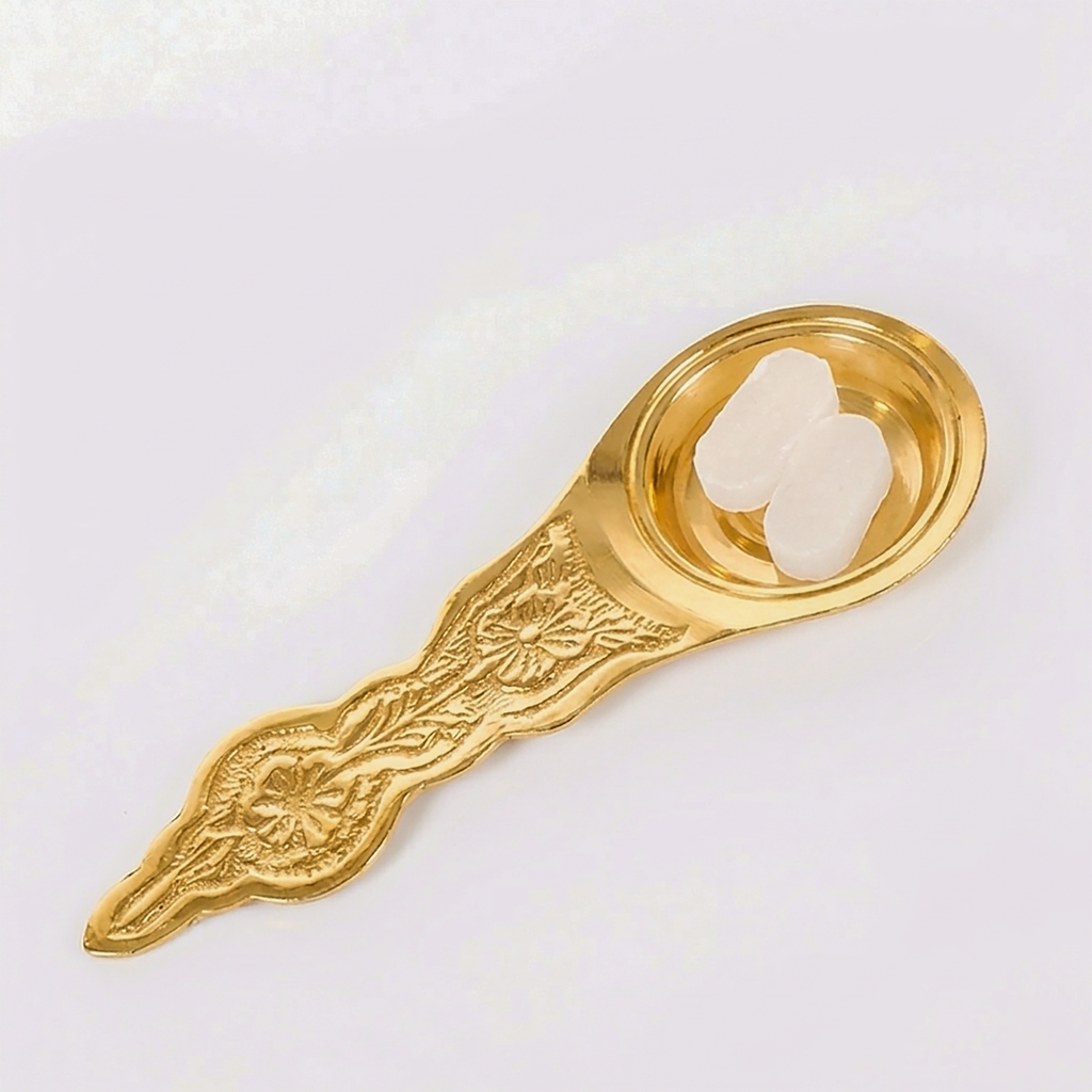 Front-facing eye-level shot of the brass karpoora aarti holder showing the entire length from the tip of the engraved handle to the circular bowl.