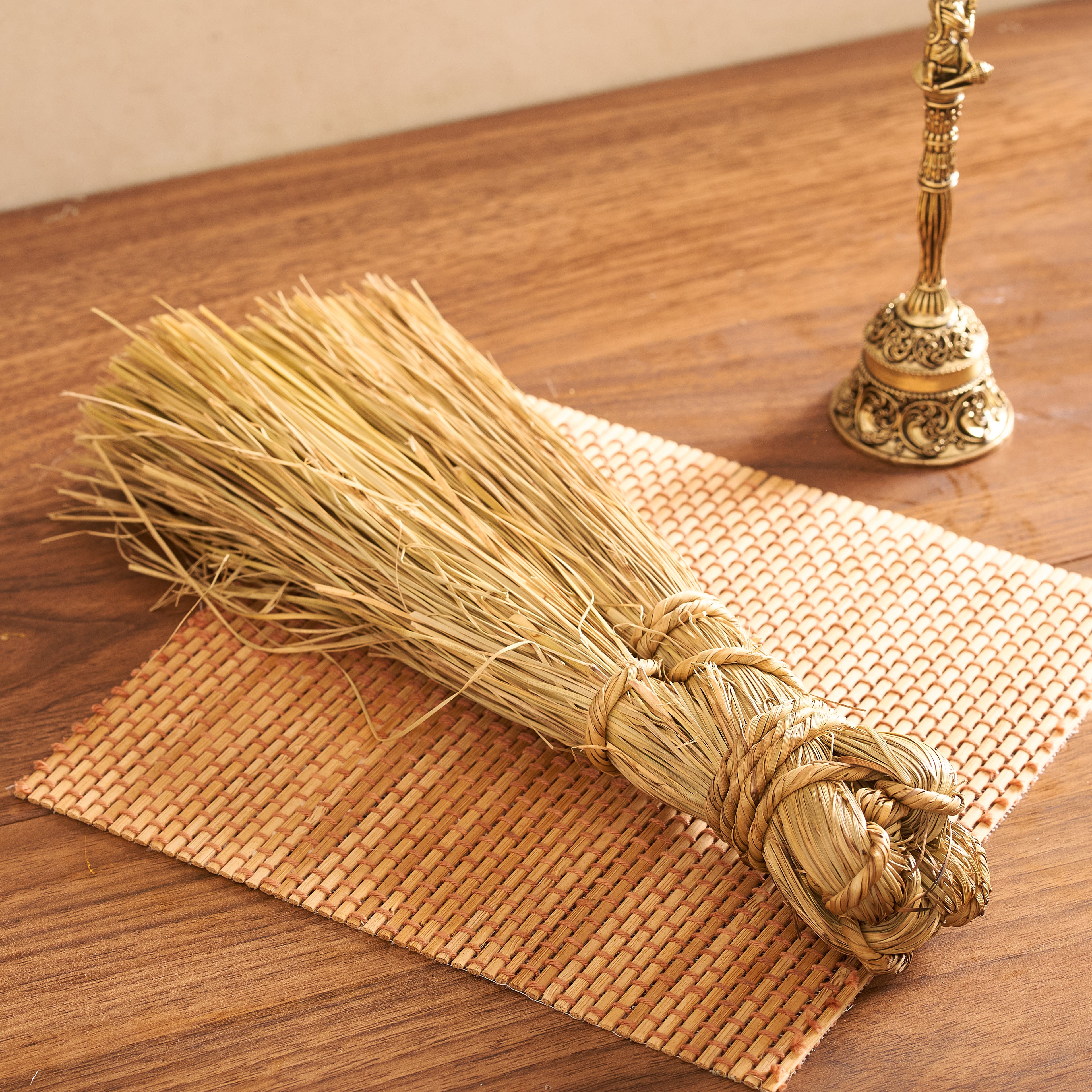 As seen in Darbar Broom_04327.jpg, a close-up angled shot focusing on the thickly bound handle and wrapped grass twine knots of the darbar broom on a light beige mat.