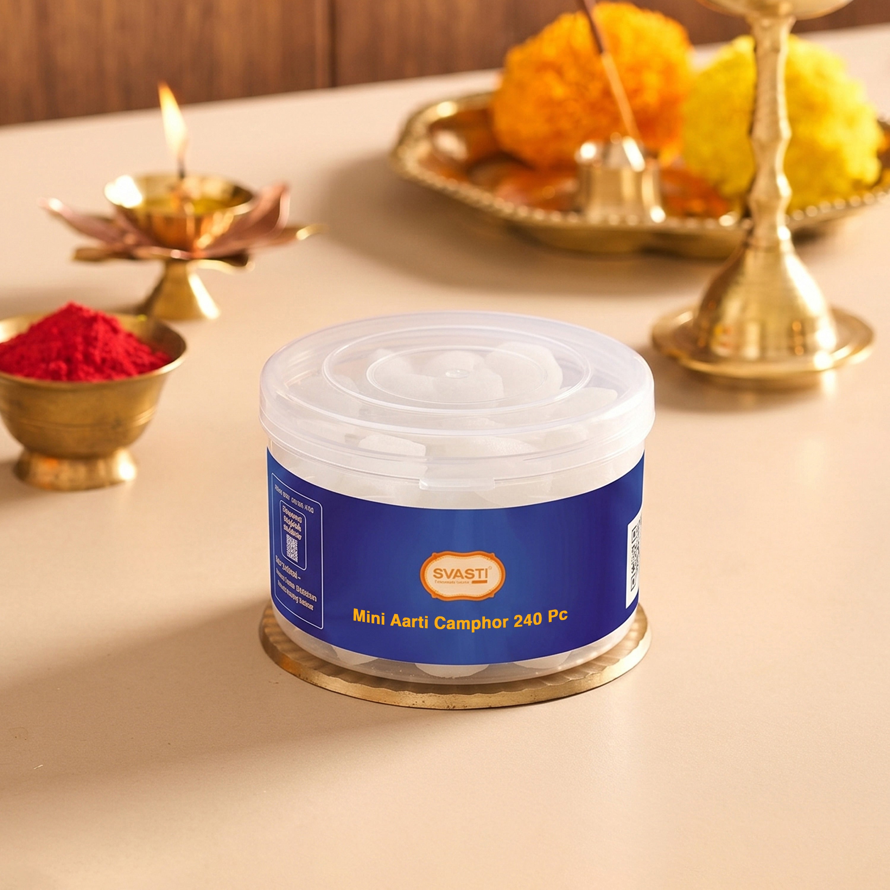 Container of Svasti Mini Aarti Camphor with Diwali decorations in the background