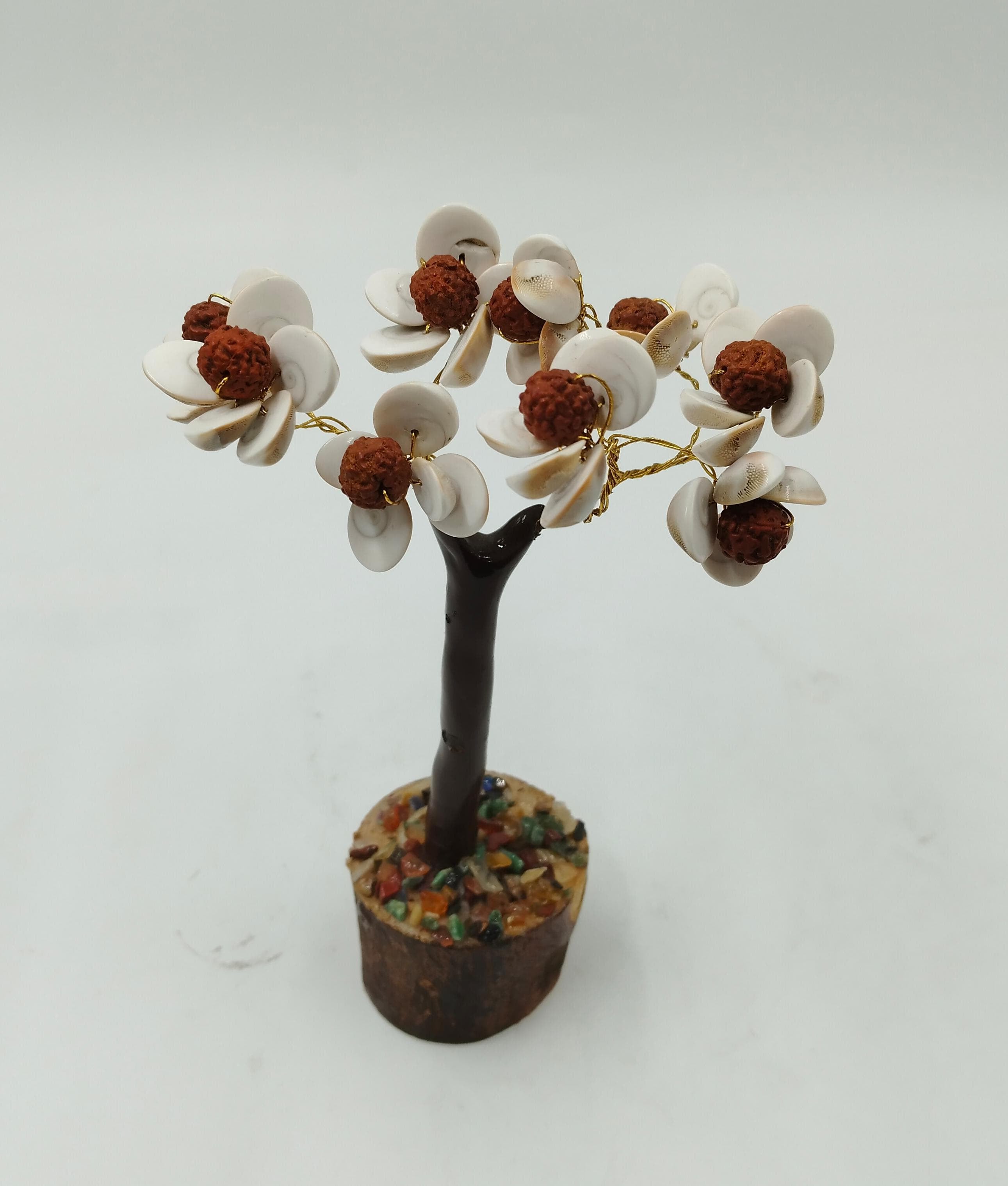A decorative Gomati Chakara tree with Rudraksha beads, featuring a trunk, branches, and shell-like fruits on a white background.