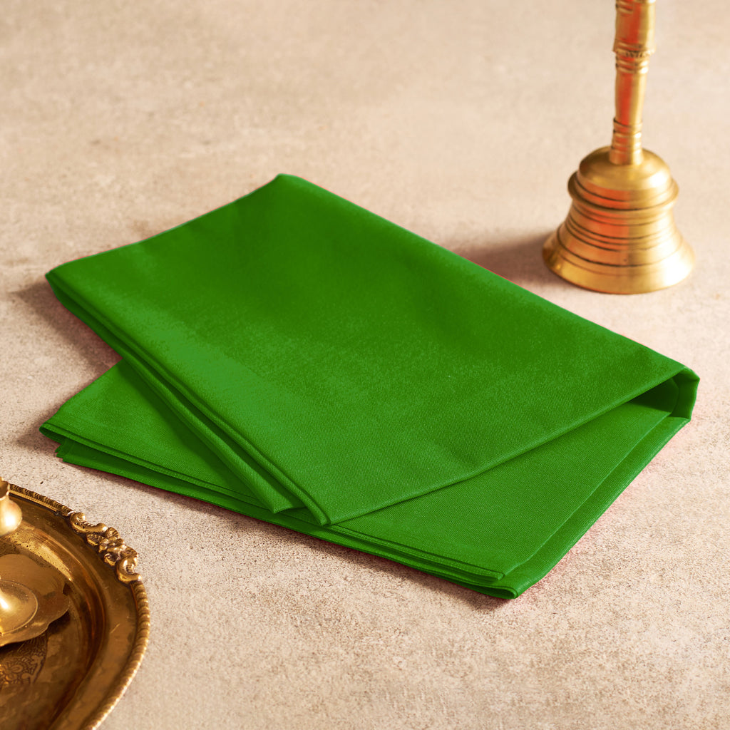 Green napkin on a beige surface with gold decorative items