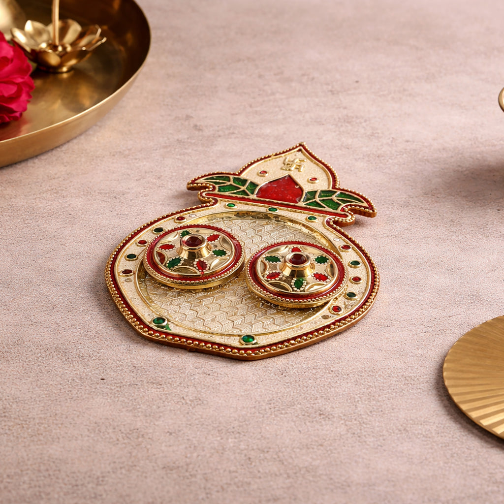 Angled overhead shot of the full kalash-shaped gold-plated haldi-kumkum tray displaying both matching vati cups sitting on the weave pattern
