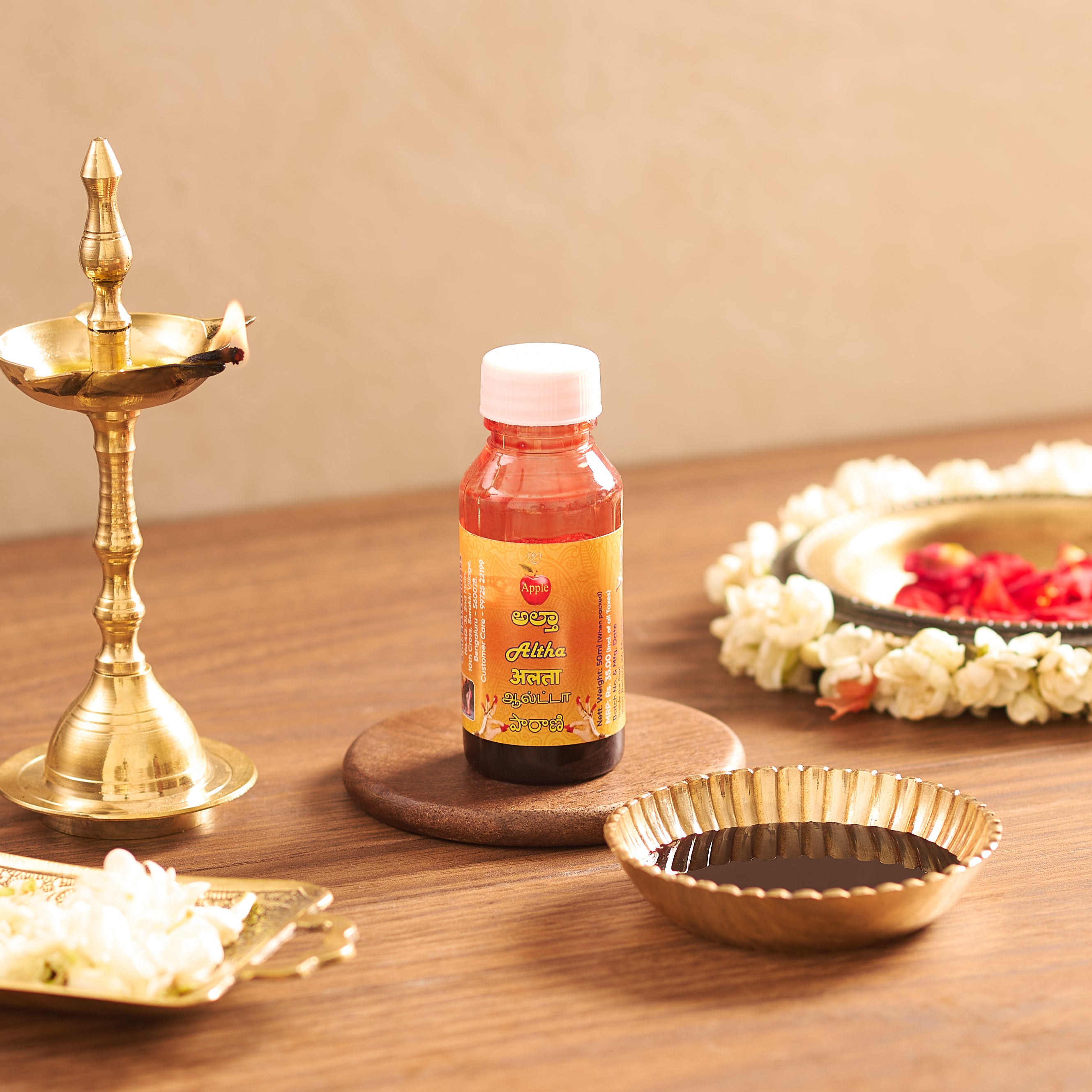 Bottle of Aitva Ayurvedic product on a wooden surface with decorative items.