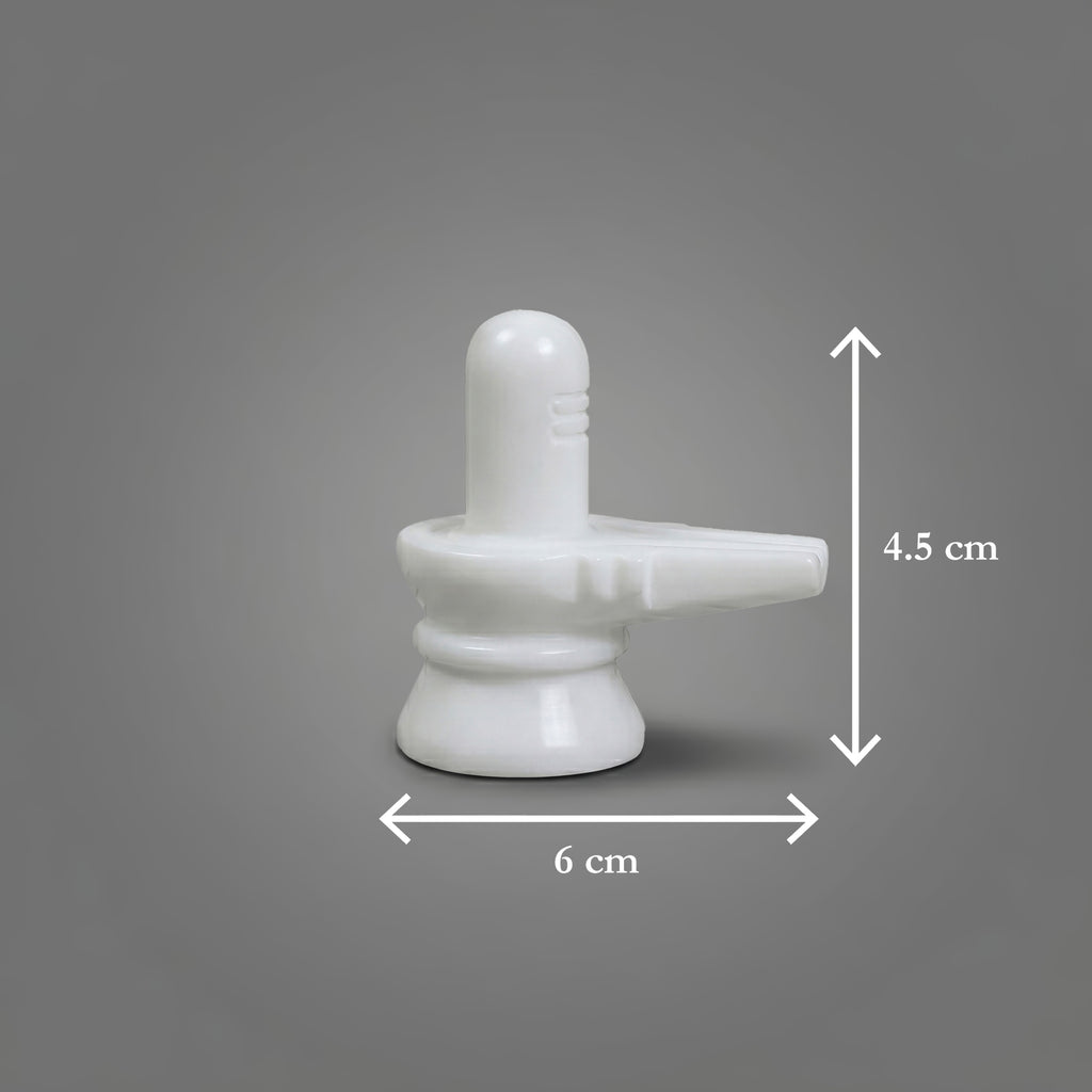 White marble Shiva Lingam with measurements on a gray background