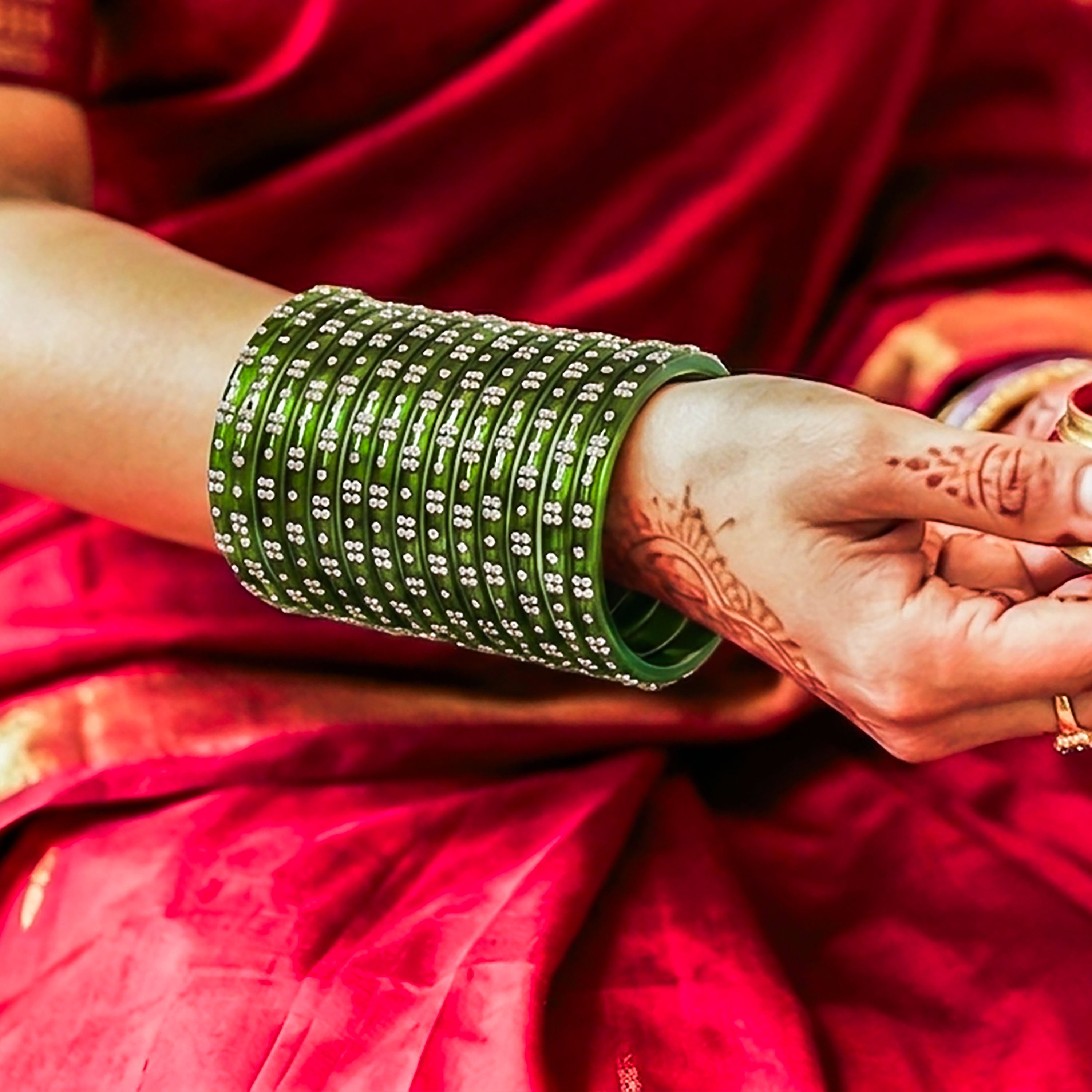 Green bracelet on a wrist with red fabric background