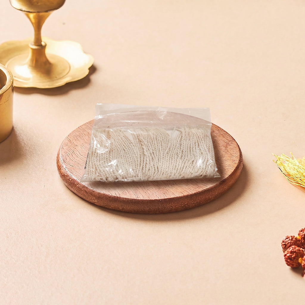 Packaged product on a wooden coaster with a candle and decorative elements on a beige background