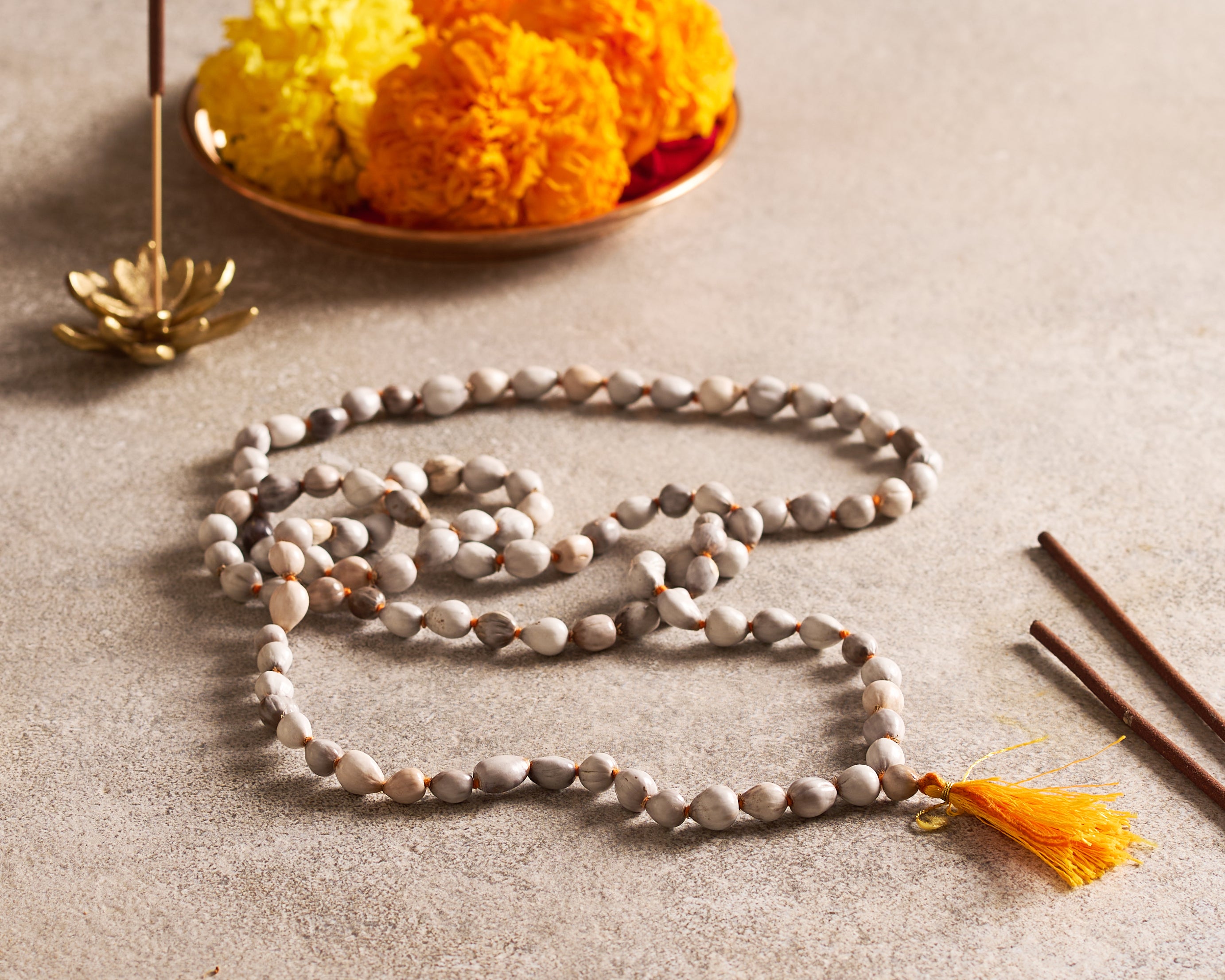 Meditation beads with a tassel on a neutral background