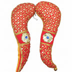 A pair of red and yellow fabric tomalas with golden embellishments and tassels, used for idol decoration.