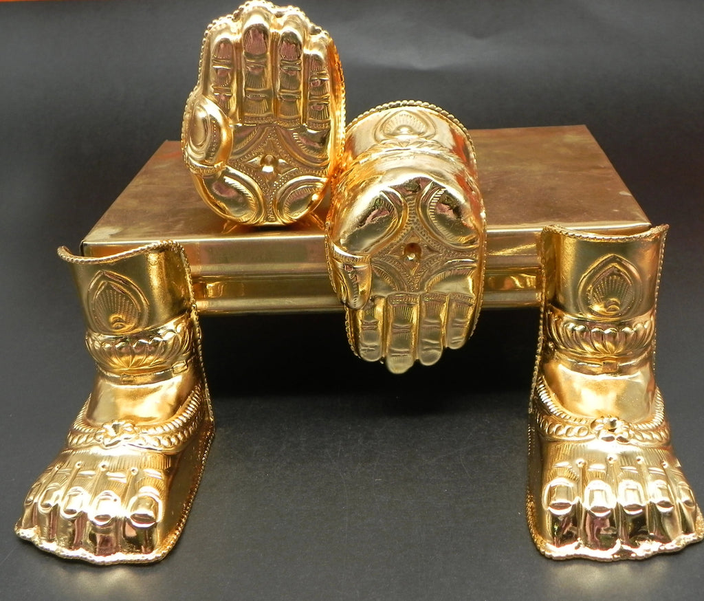 A set of gold-plated metal hands and legs figurines on a wooden surface.